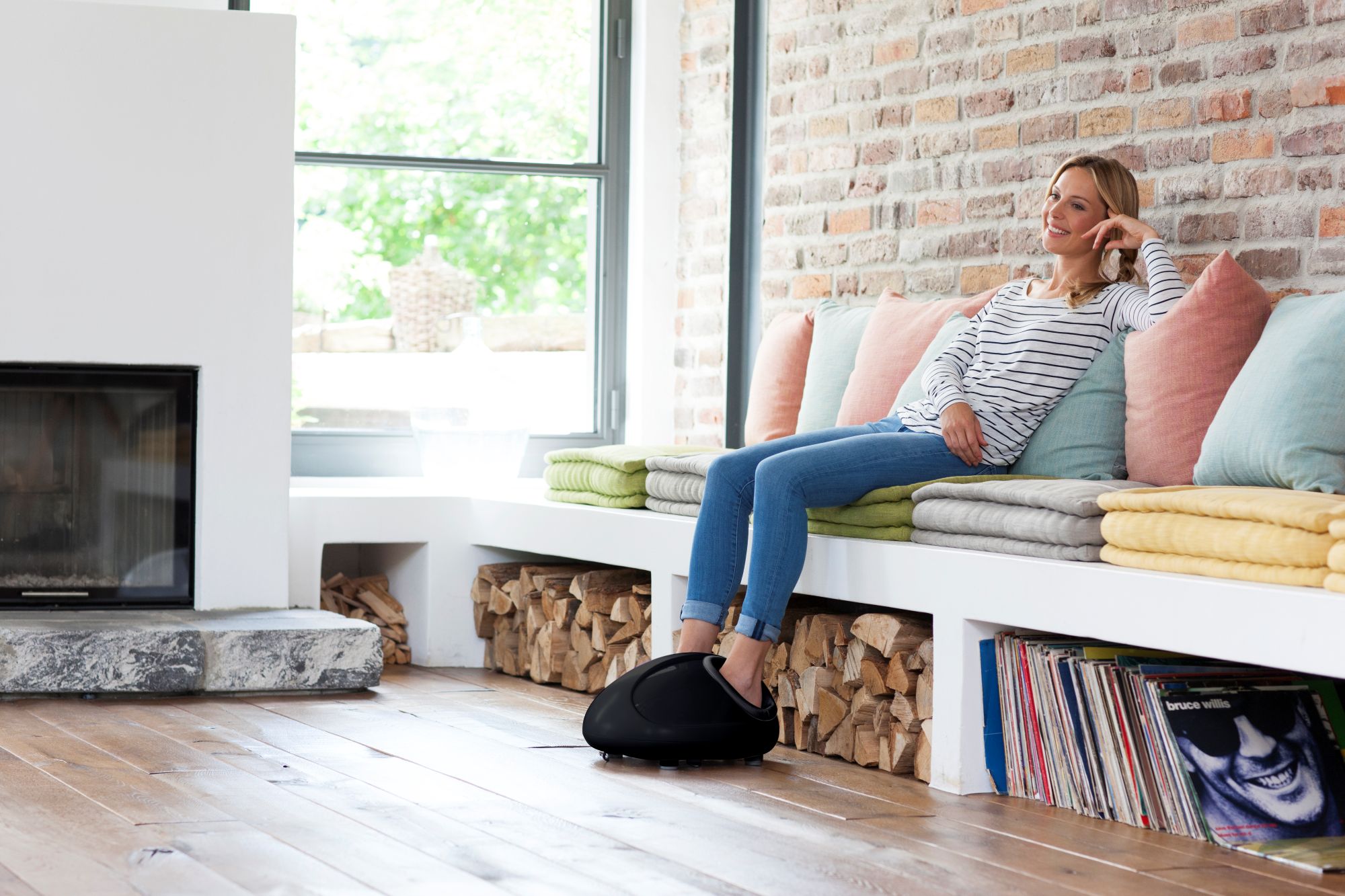 Woman relaxes at home with the medisana FM 888 foot massager - soothing shiatsu massage for tired and tense feet